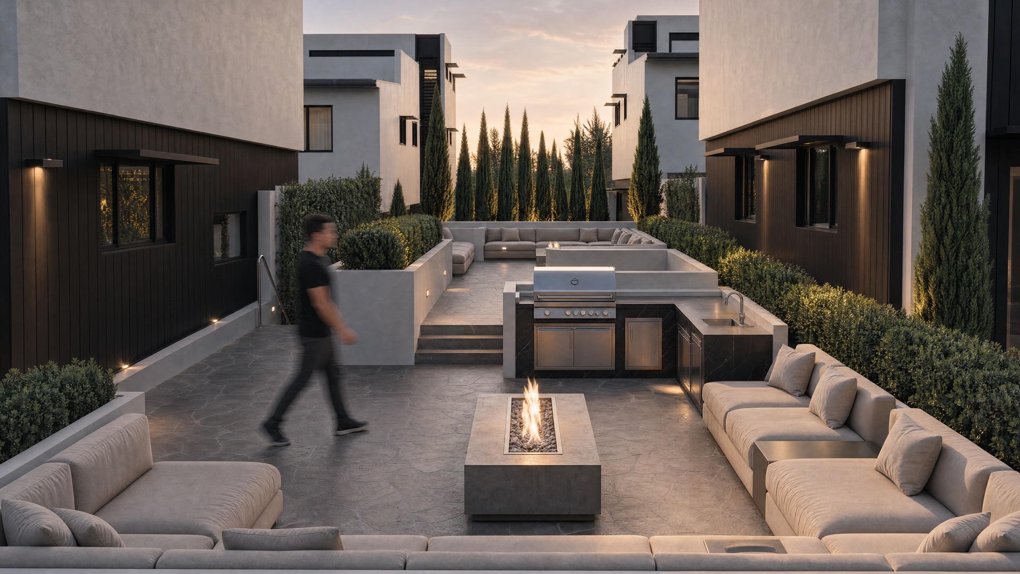 Soma — landscaped resident courtyard with outdoor kitchen, dining and firepit at dusk